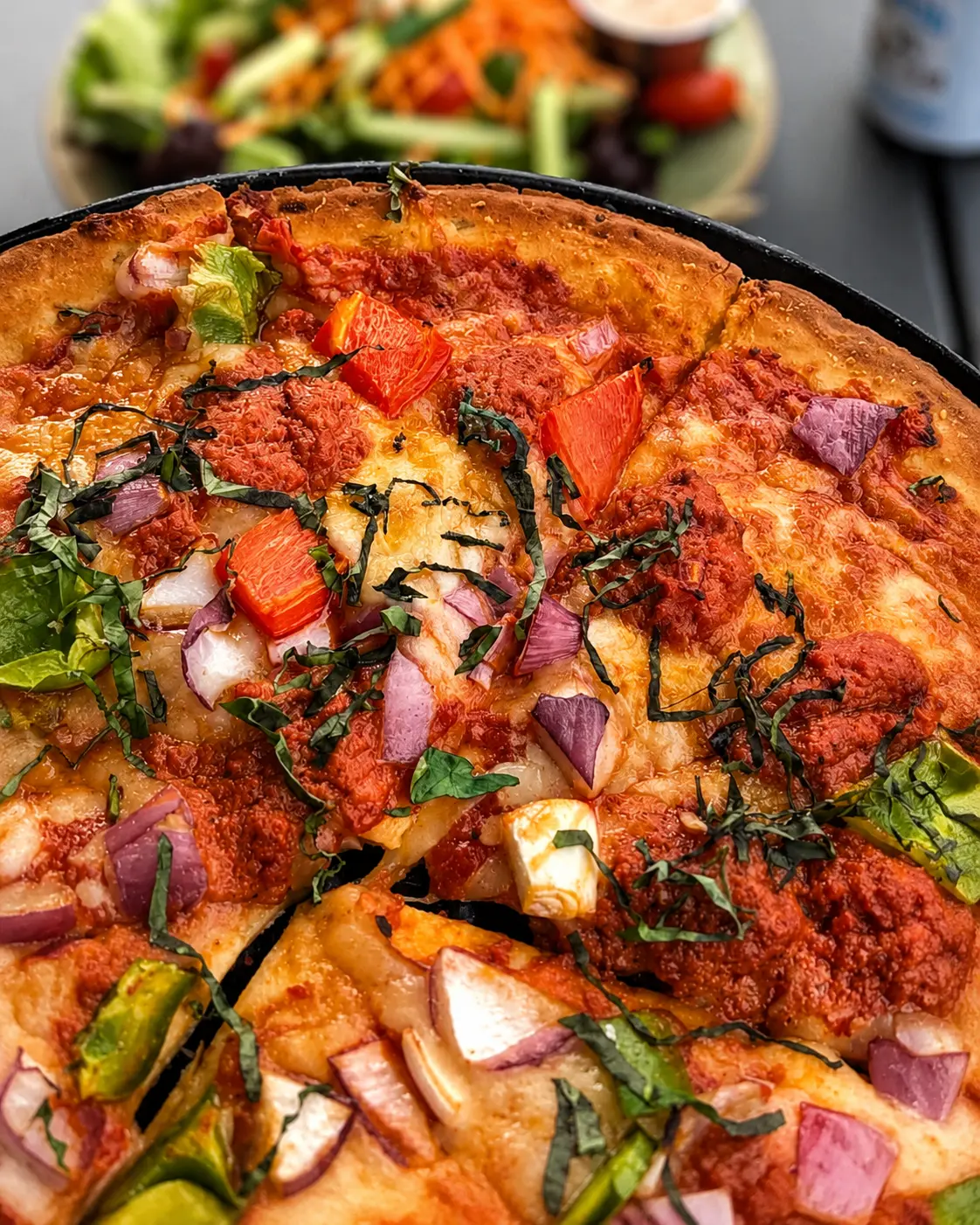 A craft margherita pizza with fresh basil and melted mozzarella, sliced on a board.